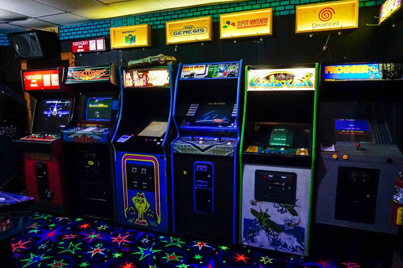 Row of classic arcade cabinets over neon star carpet