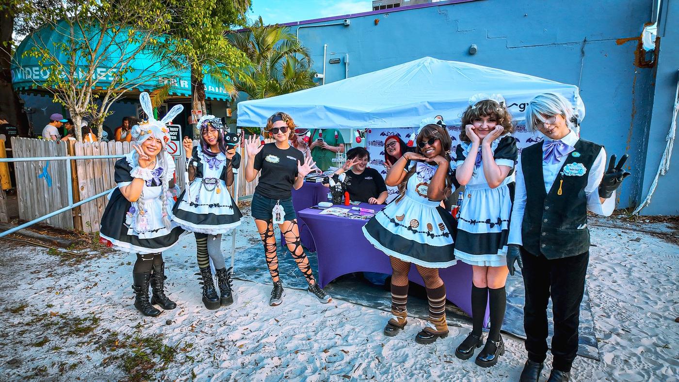 Maid café performers posing at an outdoor UVG event